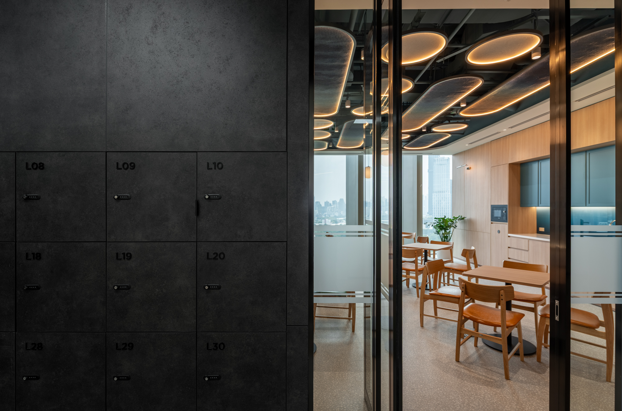 Herbert Smith Freehills Kramer Bangkok staff pantry with dark lockers, glass partitions and illuminated woven ceiling features
