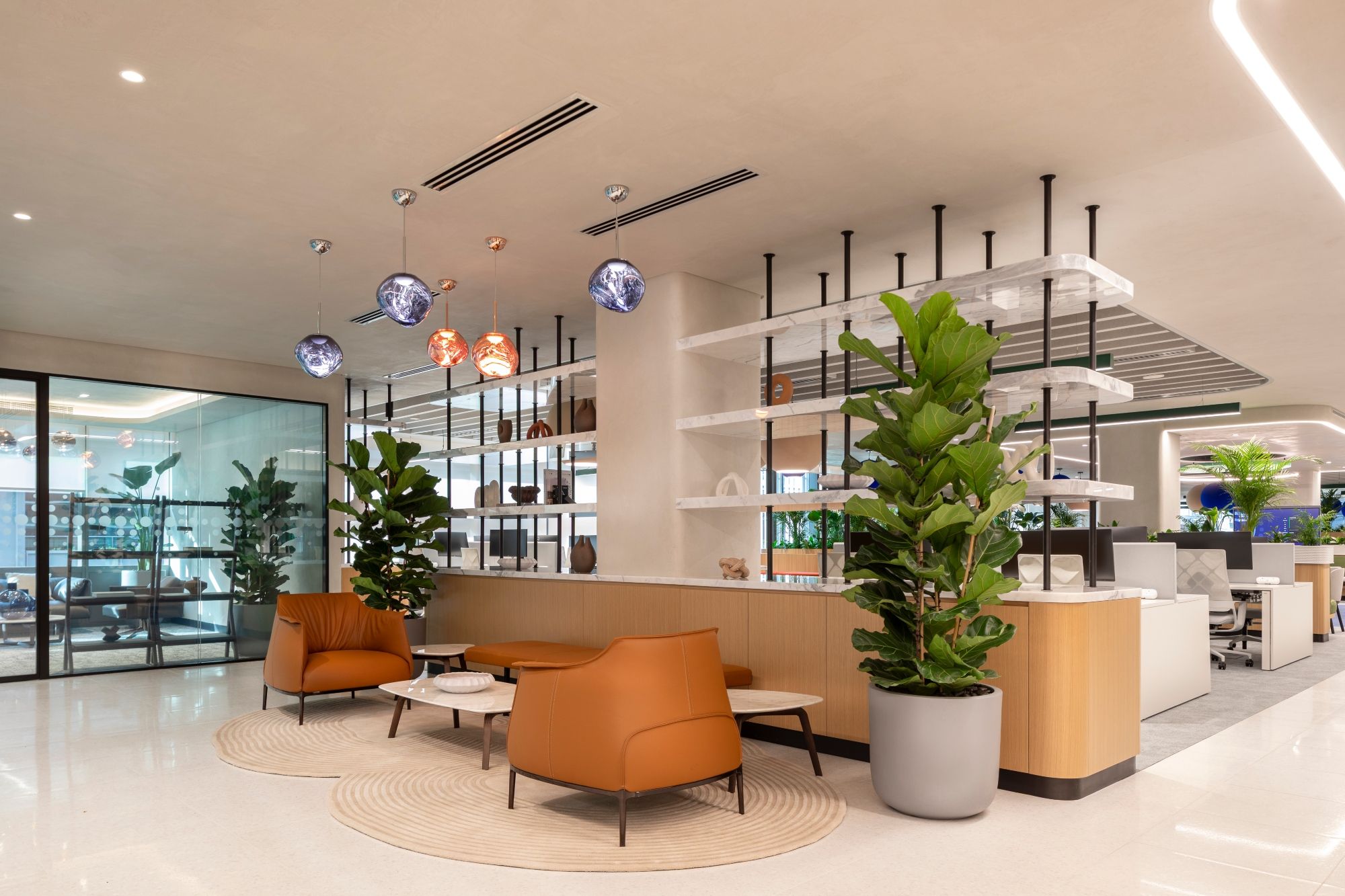 CEO waiting area at Informa Dubai by dwp, with warm timber finishes, sculptural lighting, greenery and contemporary lounge seating.