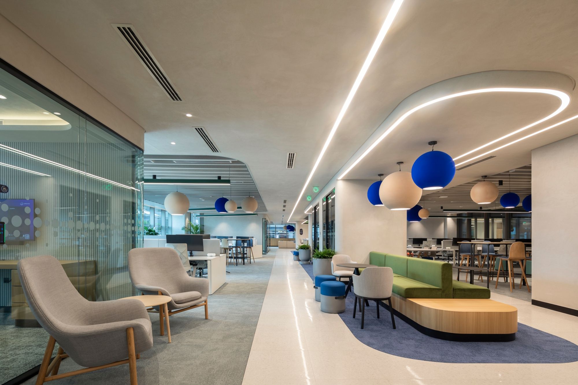 Open-plan Informa Dubai workplace by dwp, featuring flexible collaboration areas, organic forms, integrated lighting and colourful seating.