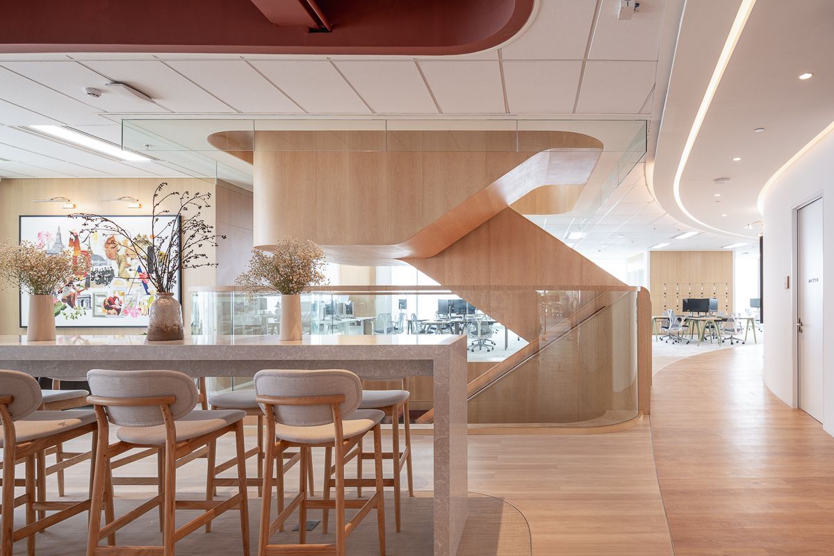 Organic curved staircase and collaboration area at L’Oréal Bangkok office designed to encourage movement and connection